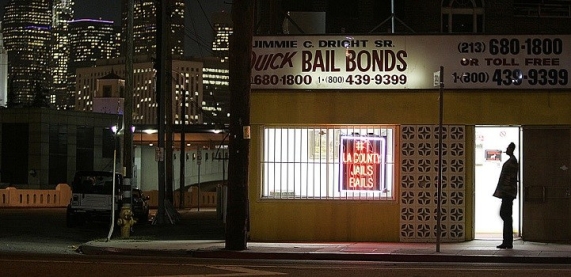 The lights of downtown Los Angeles shine behind the Quick Bail Bonds building on Vignes Street acro